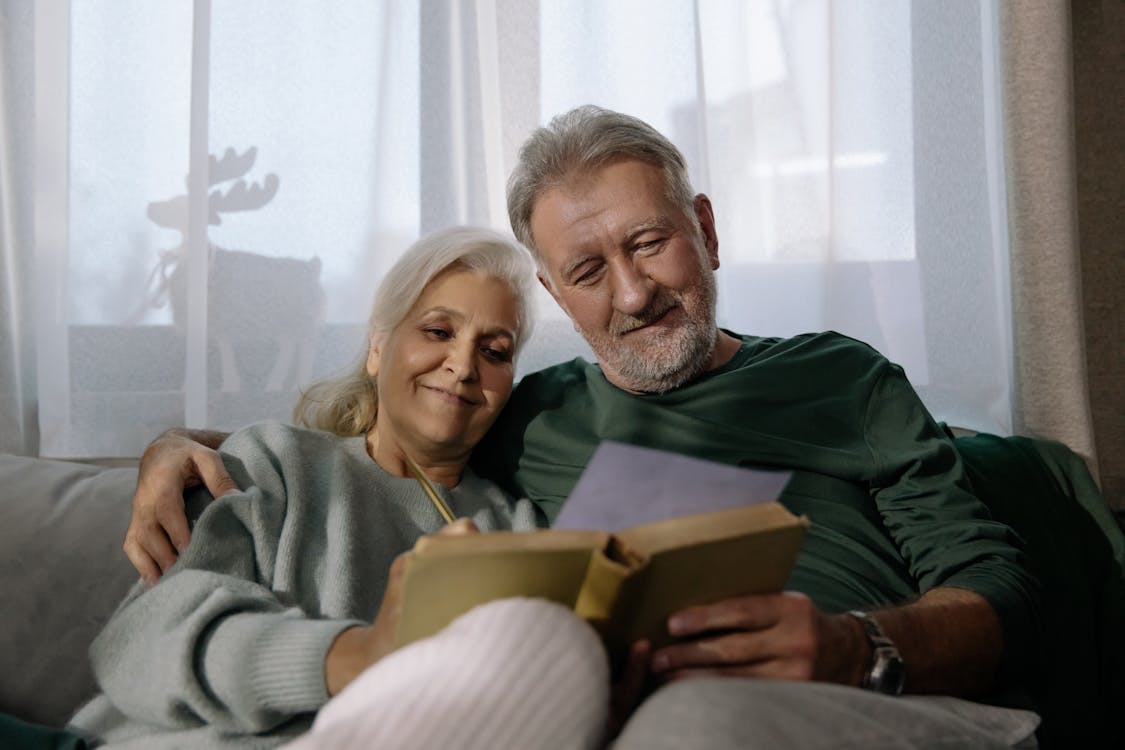 Homem e mulher aposentados lendo livro