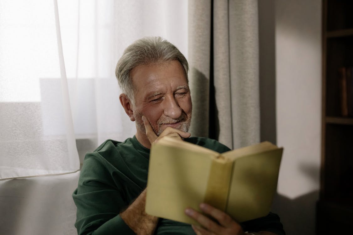 Man in Green Jacket Holding Yellow Paper Bag