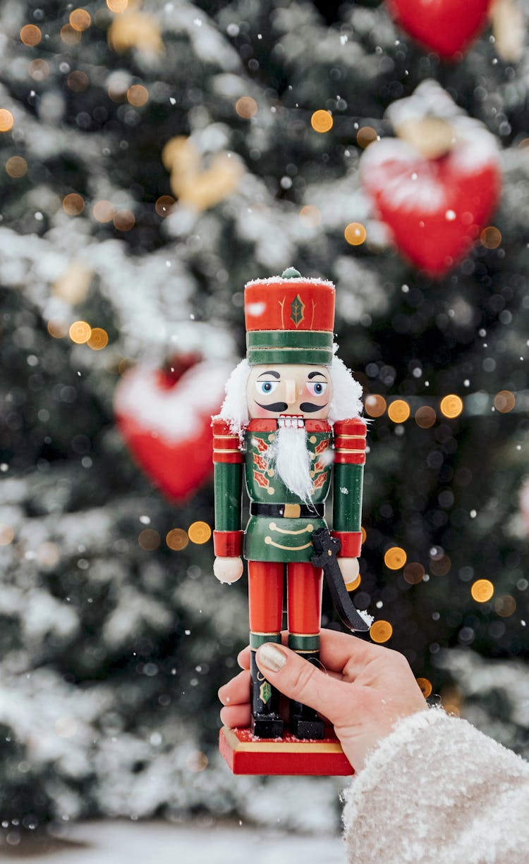 A Person Holding A Nutcracker Soldier Toy