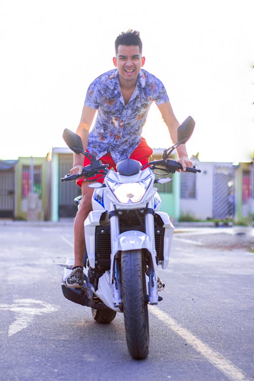 Man in White Floral Dress Riding a White Motorcycle