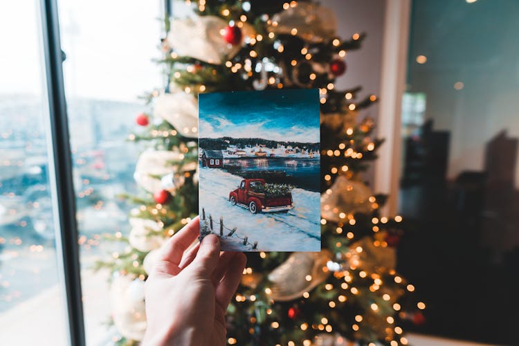 Faceless Person Showing Postcard With Painting On Christmas Day