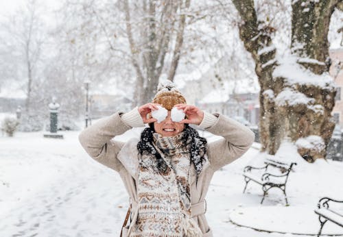 Woman in White Cardigan Holding Snowballs