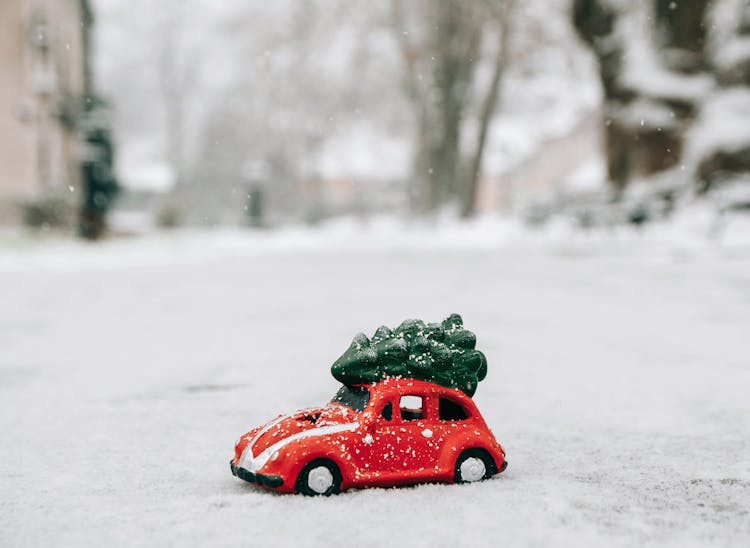 A Red Beetle Car With Christmas Tree On Top
