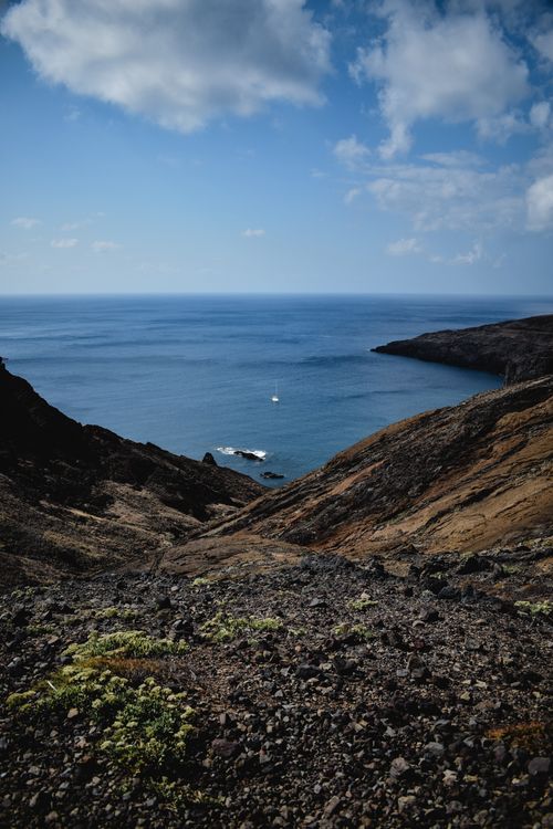 Free Breathtaking view of Madeira's rocky coastline with clear blue ocean and sky. Stock Photo