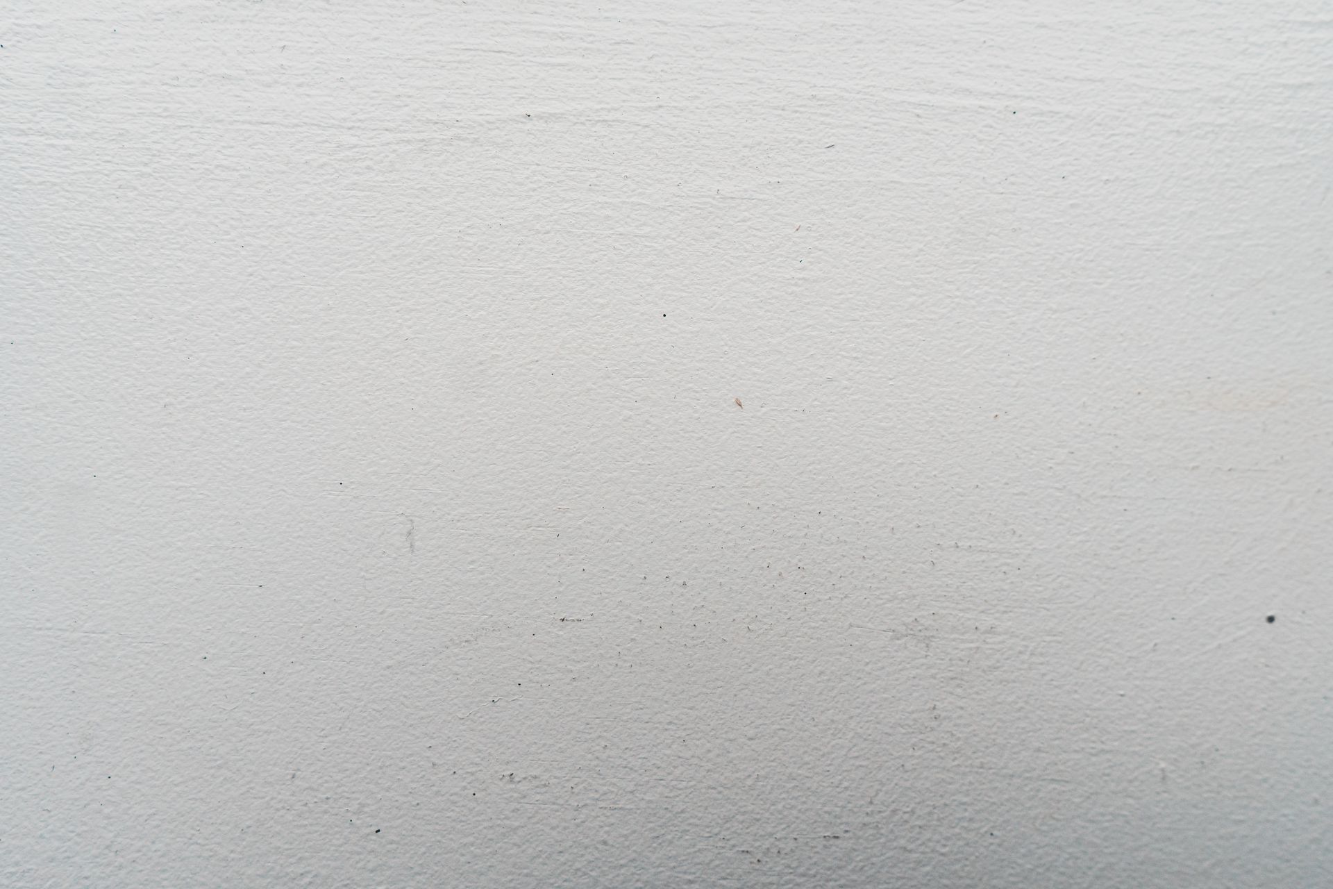 Textured backdrop of light wall with hard structure and thin wavy lines on rugged stucco in daytime