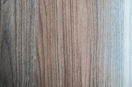 Overhead view of textured backdrop representing wooden desk of beige and gray color with curved lines