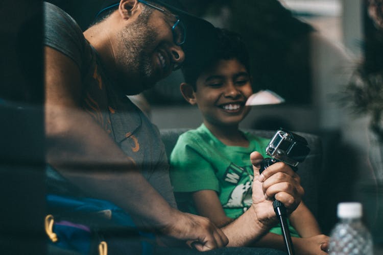 Man And Boy Looking At The Go Pro Camera 