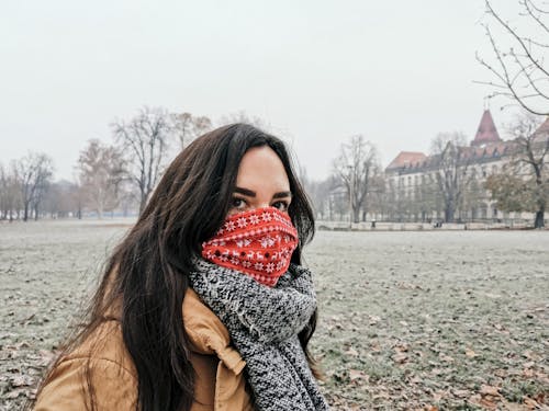 A Woman with a Gray Scarf Wearing Red and White Face Mask