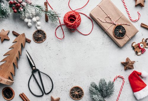 Free A festive flat lay with Christmas decorations and gift wrapping elements on a rustic surface. Stock Photo