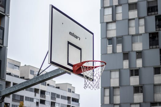 A basketball hoop set against the backdrop of modern urban architecture.