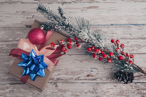 Christmas presents arranged with spruce branch with berries in snow