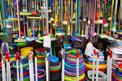 Free Various colorful mops and brushes arranged with stack of plastic basins and bins in household goods supermarket Stock Photo
