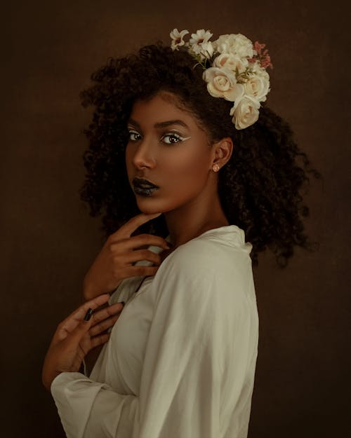Elegant black woman with creative makeup looking at camera