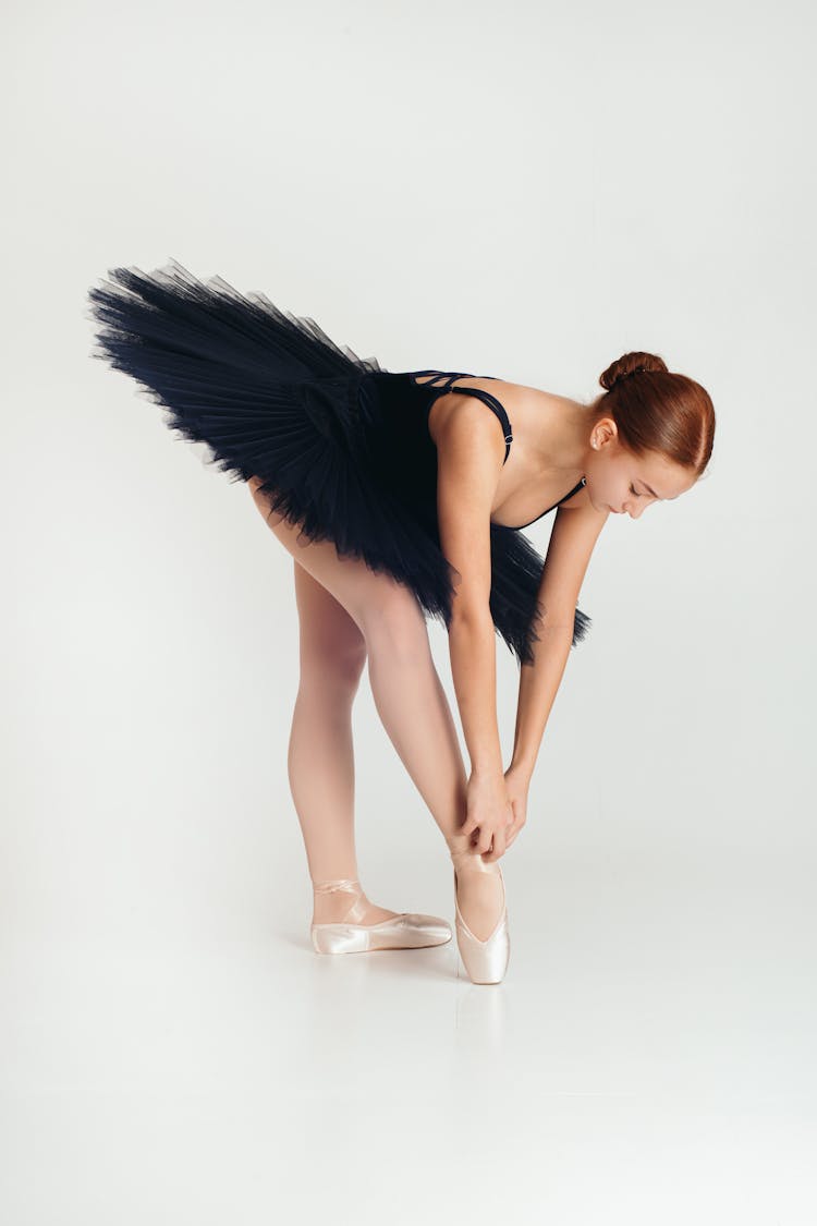 Ballerina In Black Dress Fixing Her Shoes 