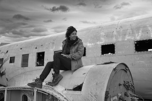 Free Woman Sitting on an Abandoned Airplane Turbine  Stock Photo