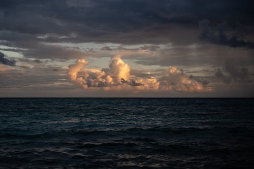 Sea Waves Under Dark and White Clouds