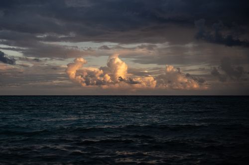 Free Captivating seascape with dramatic clouds over Playa del Carmen's ocean at dusk. Stock Photo