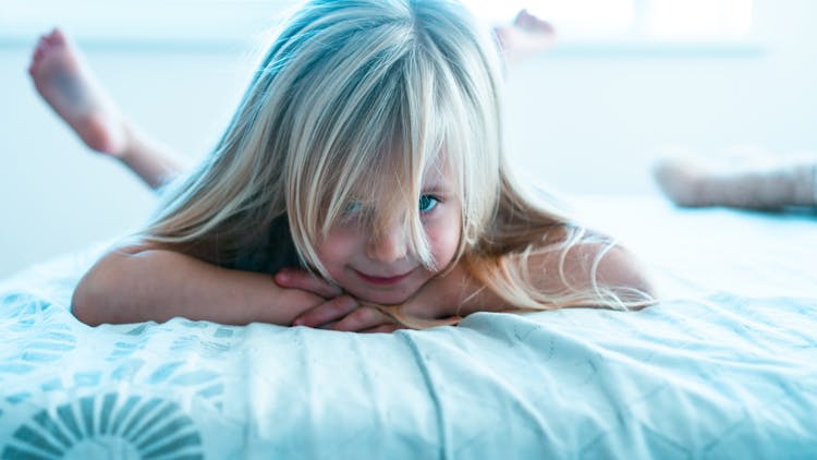 Girl With Blonde Hair Lying On Bed