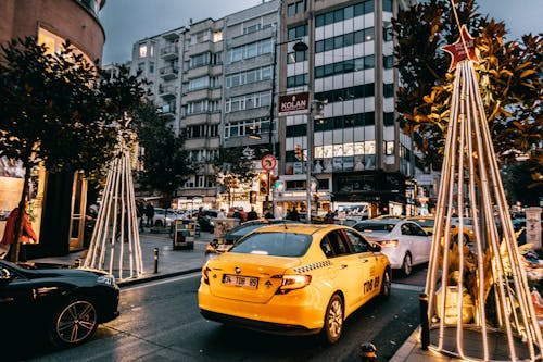 高層ビルの近くの道路にある黄色いタクシー