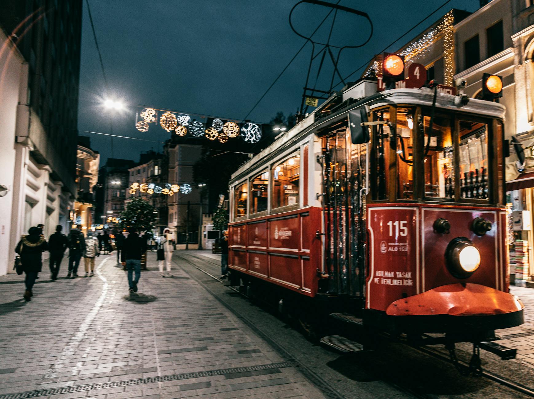 Old tram riding on railway of city decorated with garlands
