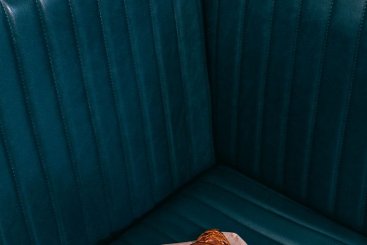 From above of appetizing crispy French roll made of sweet flaky pastry on couch