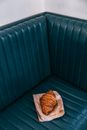 From above of appetizing crispy French roll made of sweet flaky pastry on couch