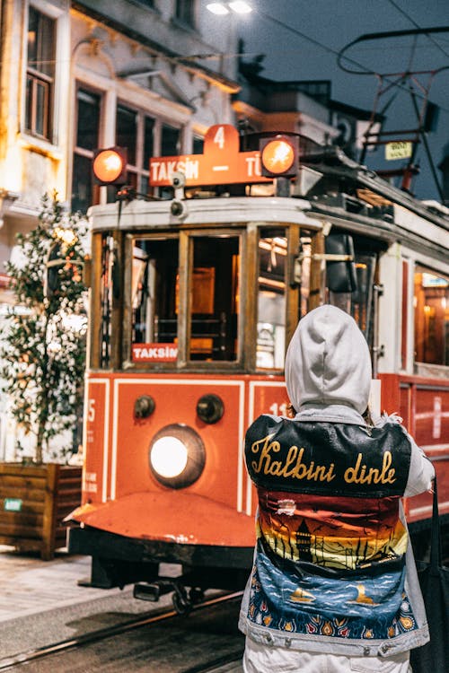 Femme En Sweat à Capuche Gris Debout Devant Le Tramway Rouge Et Jaune