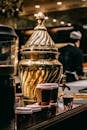 Samovar for brewing Turkish beverage Sahlep and paper cups placed on counter in restaurant