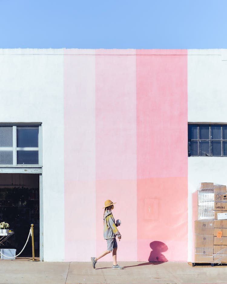 Person Walking On Street Near Colorful House