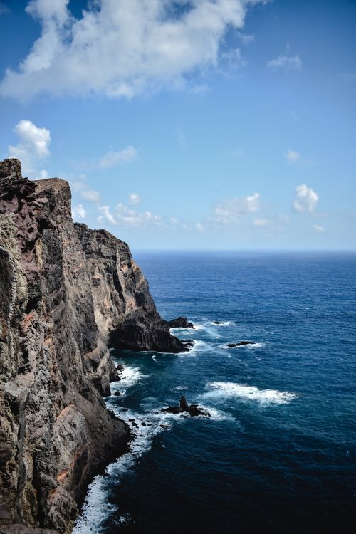 Free Breathtaking view of rocky cliffs and azure ocean waves in Madeira, Portugal, under a clear blue sky. Stock Photo