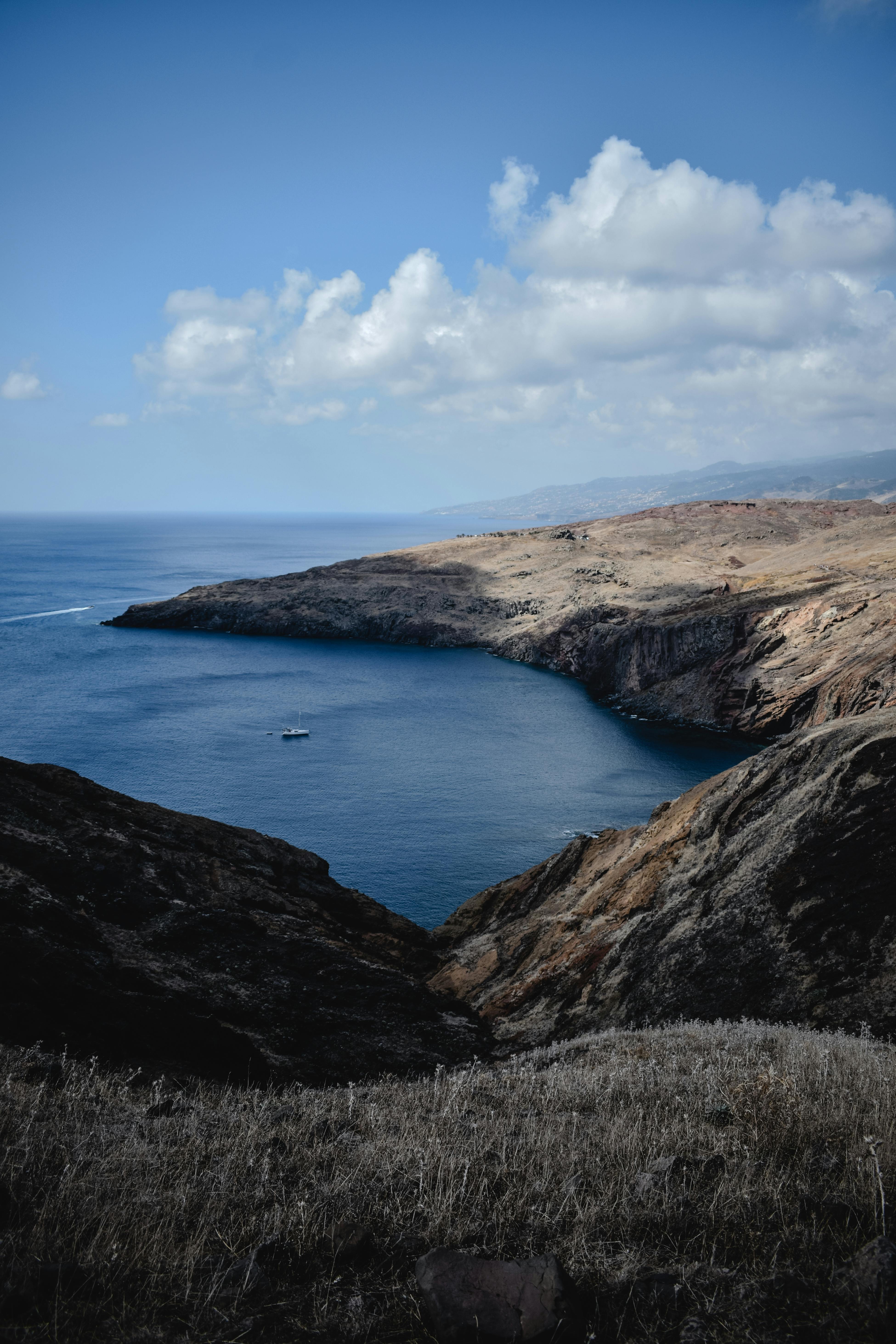 brown cliff coast beside blue sea