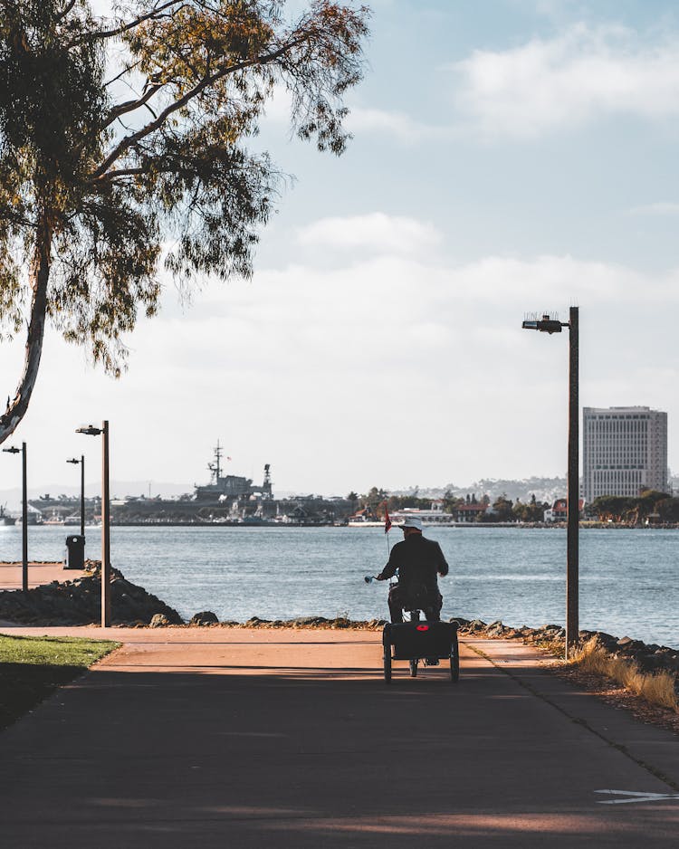 Person In Three Wheeler Bike On Walkway