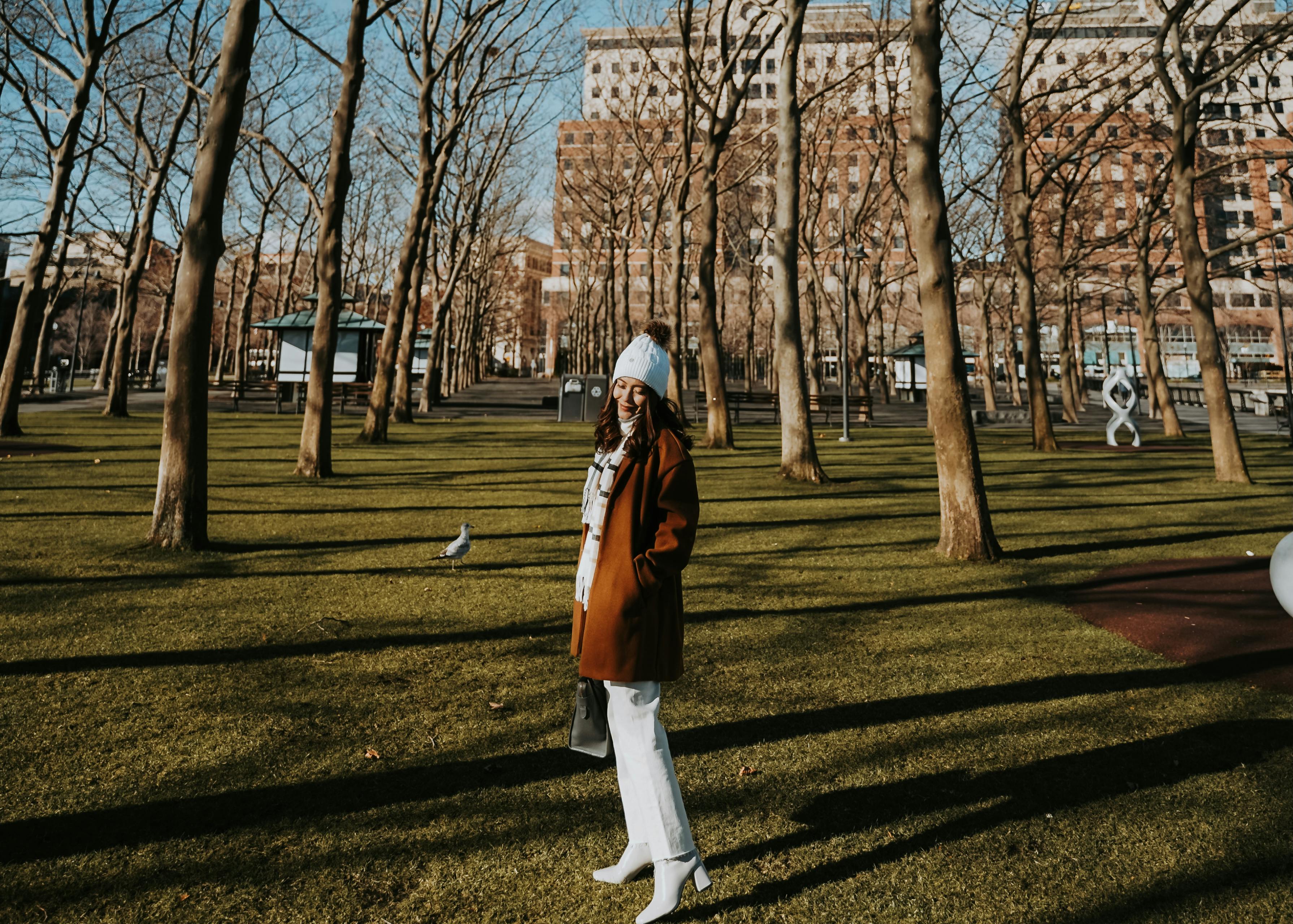 woman in casual wear standing near bare trees