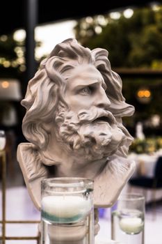 Detailed close-up of a classical gypsum bust sculpture with blurred background, ideal for art and design themes.