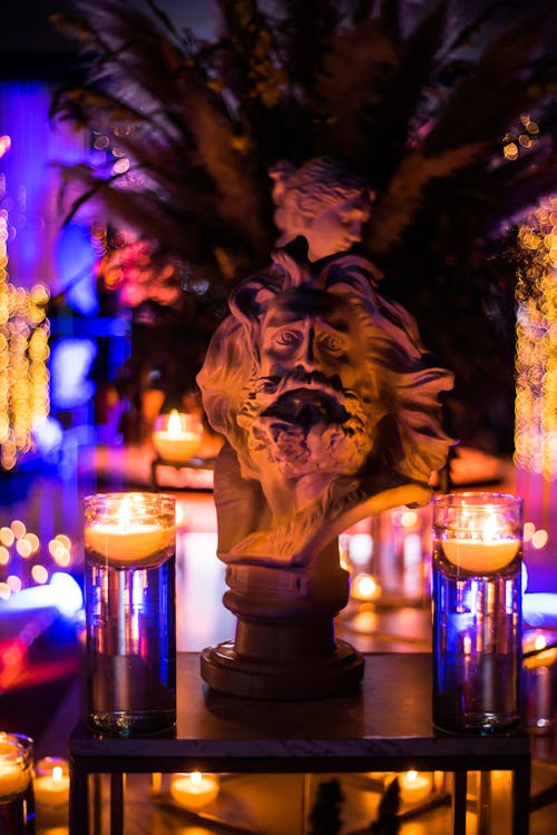 A Gypsum Head beside Lighted Candles on a Table