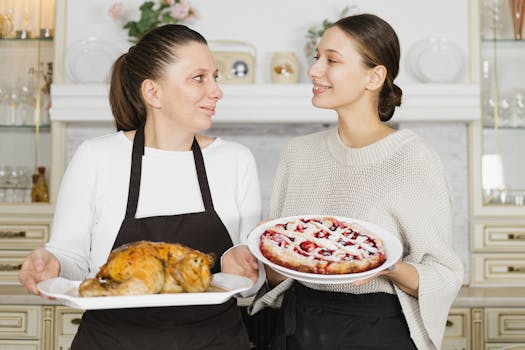Mother and daughter bonding while baking together in the kitchen. Holding a pie and roasted chicken.