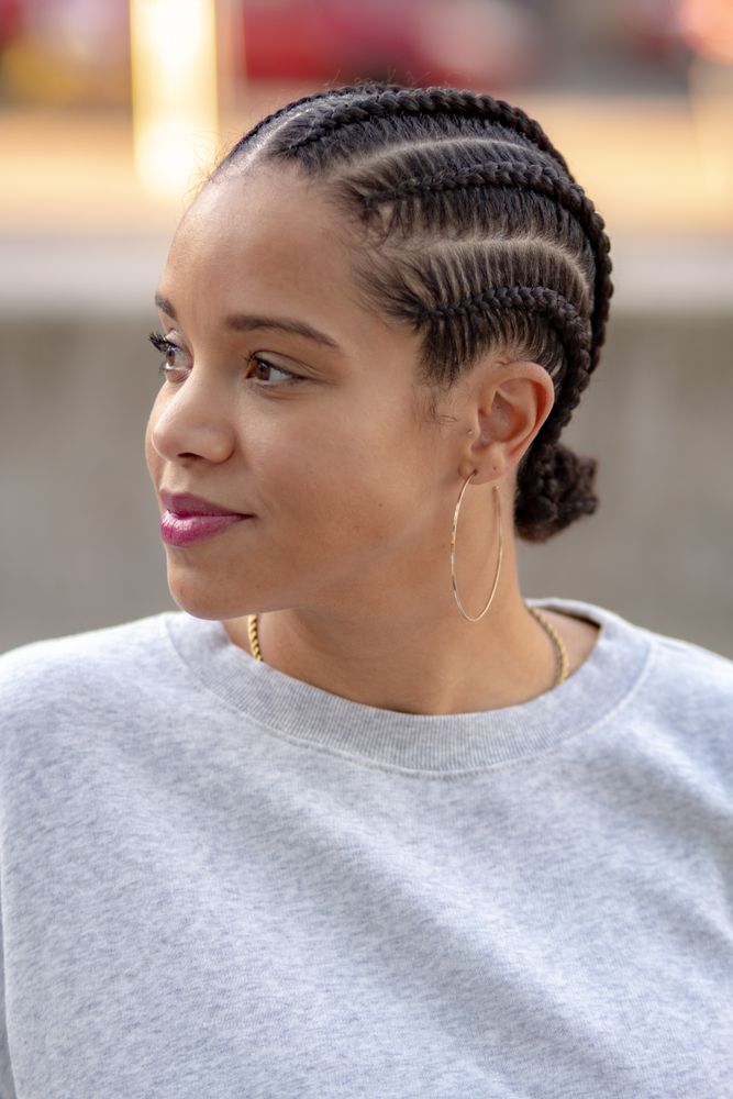 Woman in a grey sweatsuit with gold hoop earrings