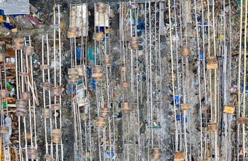 From above of settlement with wooden planks among rubbish placed in local landfill in countryside in daytime