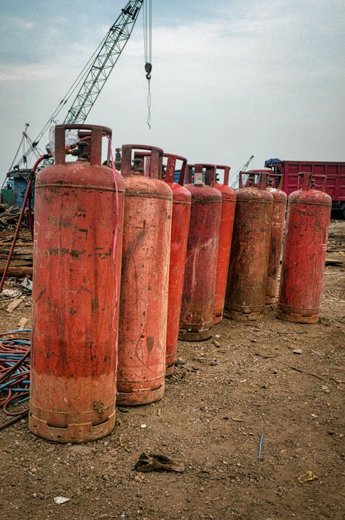 Free Old gas tanks placed on dry ground in daytime Stock Photo