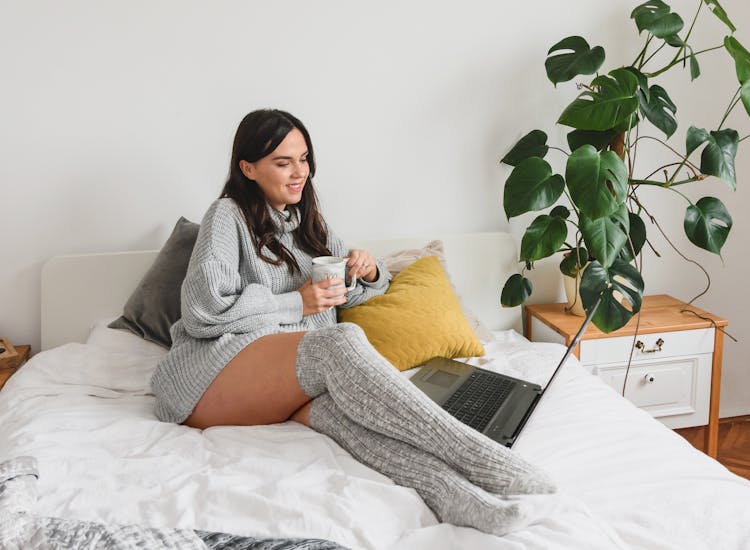 Cheerful Woman With Hot Drink Watching Movie On Laptop