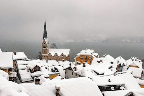 Aged church and residential houses against foggy sea in winter