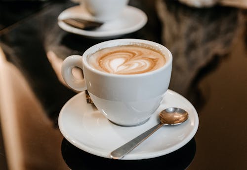 Free Cup of delicious hot cappuccino on saucer Stock Photo