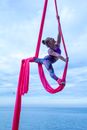 Girl in Pink Jacket and Purple Pants Riding on Red Swing