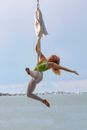 Woman in White Long Sleeve Shirt and White Pants Jumping on Water
