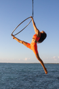 Woman in Pink Tank Top and Blue Denim Shorts Doing Yoga Pose on Beach