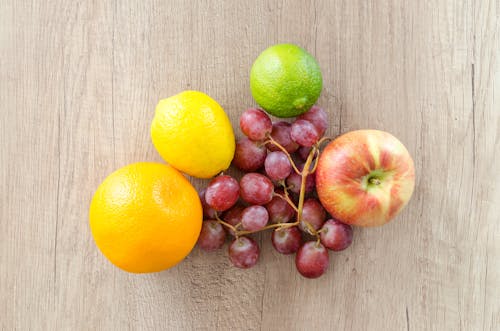 бесплатная Пять фруктов разных цветов на черной деревянной поверхности Стоковое фото