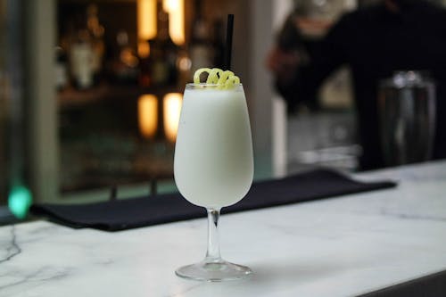 Glass with cocktail on counter in bar