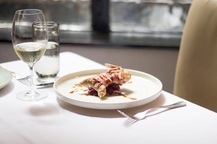 Plate With Roasted Bird Near Glasses With Drinks Near Cutlery