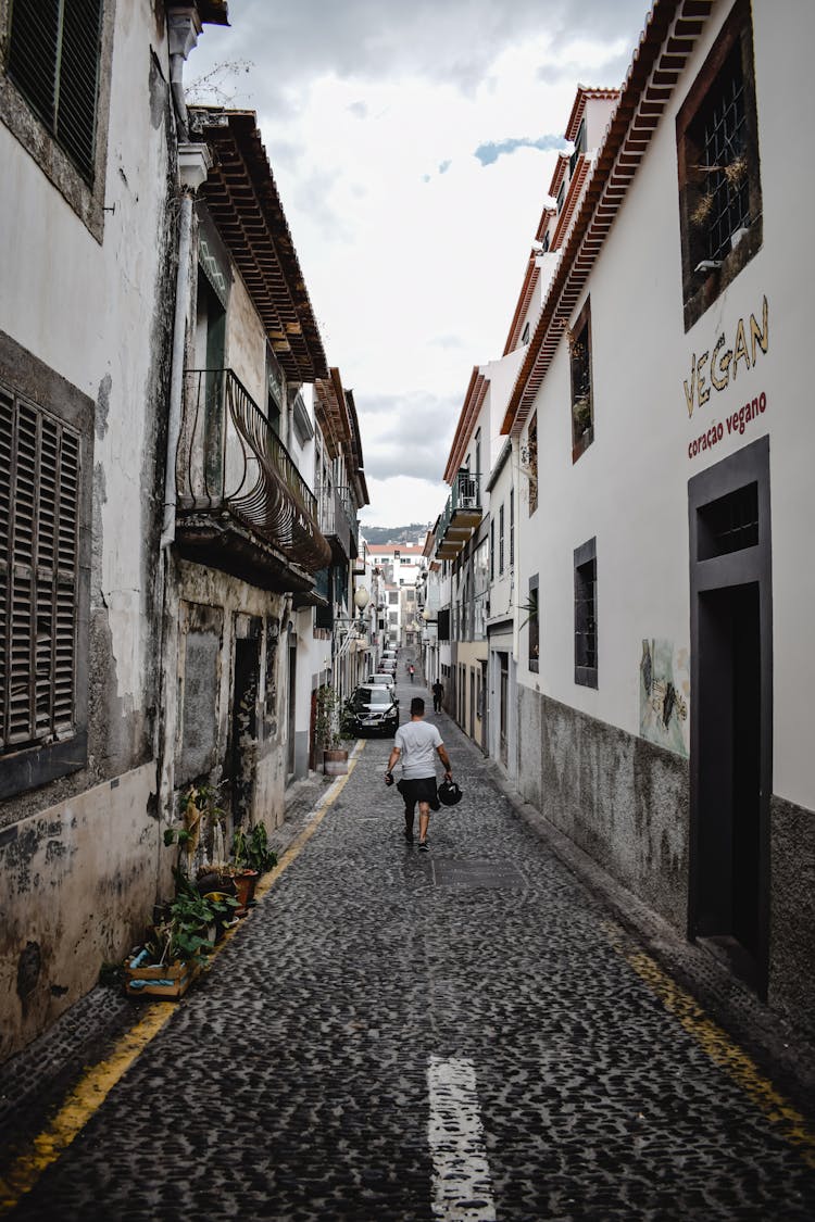 A Person Walking On The Narrow Street