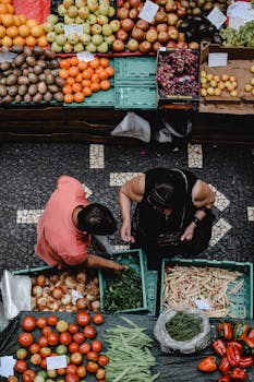 High-angle view of people shopping at a colorful fruit market in Funchal, Madeira.